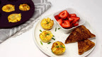 Plate with egg muffins baked with Epicure 3 Onion Dip Mix, toast, and strawberries on a white surface