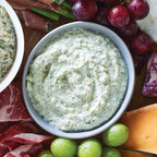 Bowl of Epicure 3 Onion Dip on a charcuterie board with fruits and meats