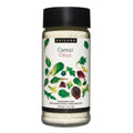 A bottle of Epicure Caesar Dressing Mix on a solid white background. The clear bottle shows the light beige dressing mix inside, topped with a black cap and featuring a white label decorated with green and red leaf illustrations.