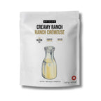 A white stand-up pouch of Epicure Creamy Ranch Ranch Crémeuse dip mix, featuring a graphic of a glass bottle with pale yellow dip inside and text indicating gluten free, sugar free, and sodium free.
