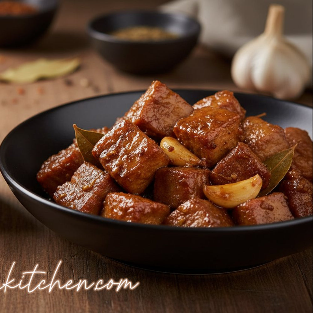 Bowl of cooked meat with Adobo seasoning jar on a wooden table
