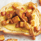 Close-up of toasted bread slices spread with yellow mustard and drizzled with peanut butter, topped with Baked Apple Sweet Dip Mix Epicure, with other spreads partially visible on adjacent slices.