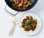 Beef & Broccoli Stir Fry Seasoning with saucy beef and broccoli served over white rice, alongside a skillet of stir fry and wooden chopsticks