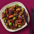 Vegetables roasted with Epicure Candied Yams Seasoning on a white plate sitting on a purple tablecover