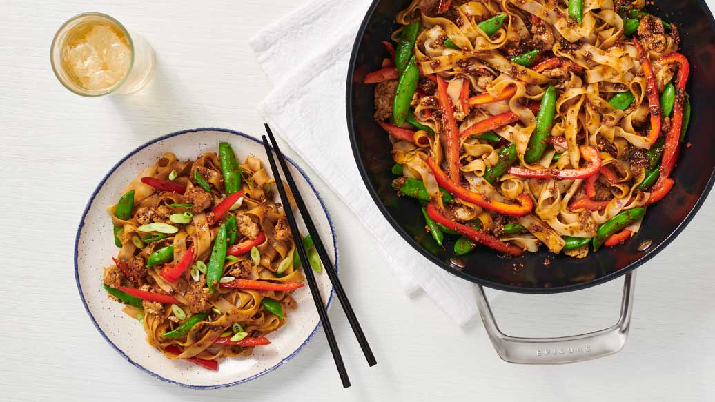 Chicken Fried Rice Seasoning meal with stir fried rice noodles colorful bell peppers green beans and chicken served in a skillet and bowl with chopsticks beside it