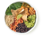 Vibrant bowl of salad with tortilla chips, guacamole, and vegetables on a white background