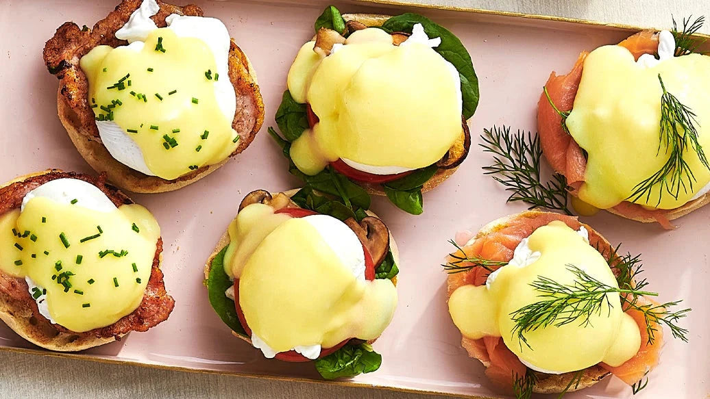 Hollandaise Sauce Mix served over poached eggs on English muffins with ham and smoked salmon garnished with chives and fresh dill on a platter