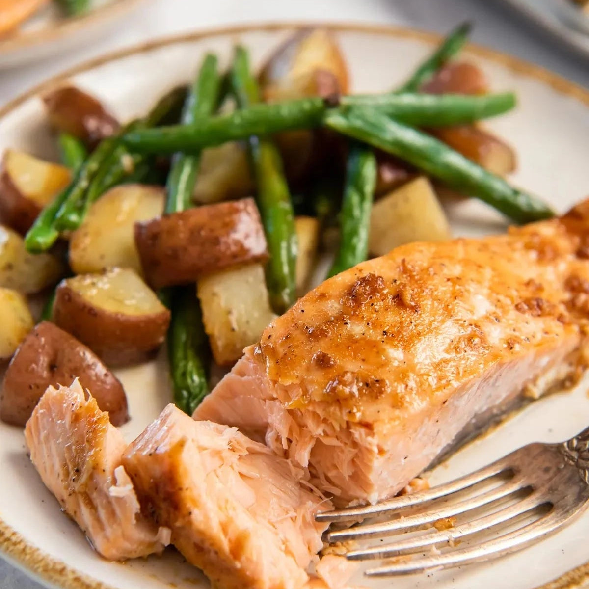 Sliced salmon with potatoes and green beans on a plate