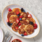 Platter of pancakes with berries on a marble surface