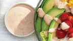 Prepared Epicure Southwest Ranch Dressing with salad bowl on a marble background