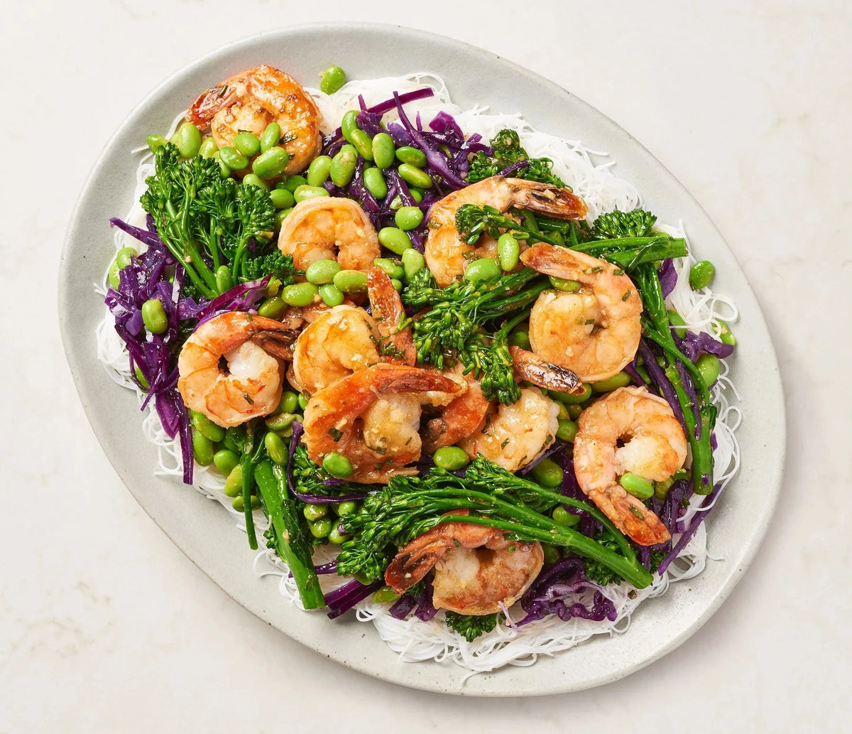 Plated dish of shrimp with vegetables on a white background