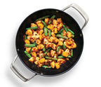 Black frying pan with Sweet & Sour Stir Fry by Epicure featuring cauliflower, green beans, and other vegetables on a white background