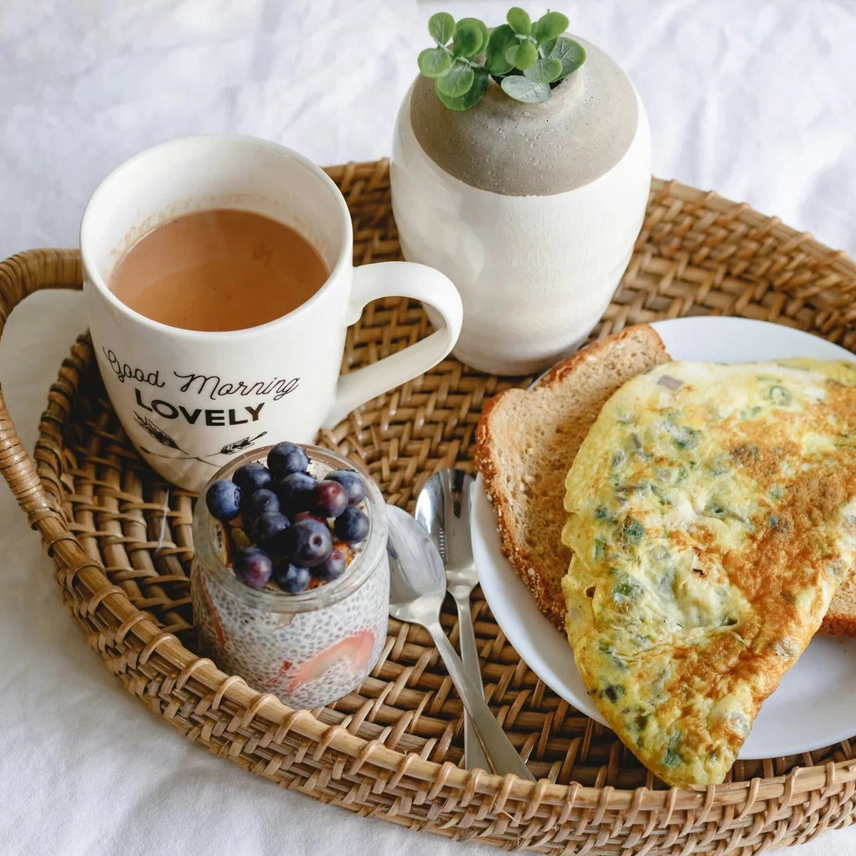 Breakfast tray with coffee, toast, and omelette on a white surface